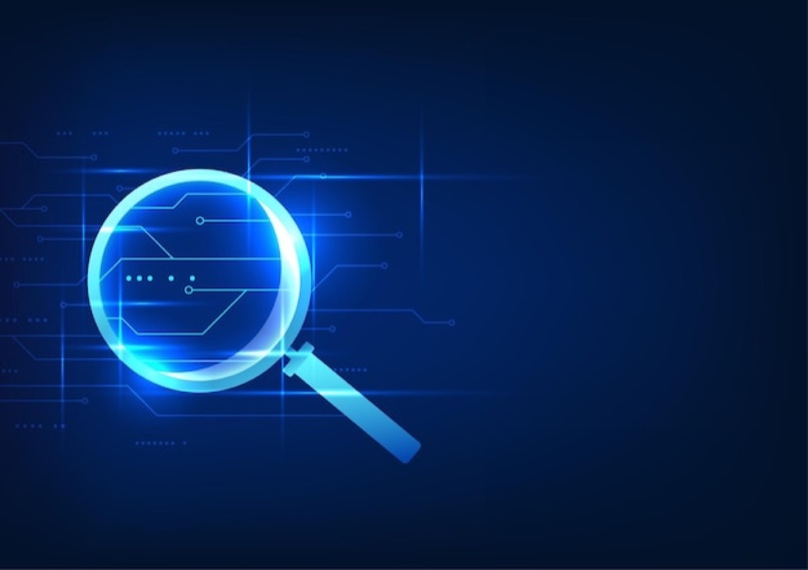 Magnifying glass searching through digital technology circuits