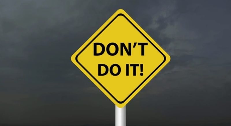 Yellow Don't Do It warning sign against a stormy sky, introducing the tactics brands must avoid when optimising for AI product recommendations