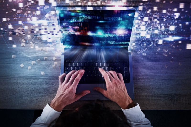 Person typing on laptop researching AI search strategies and content optimisation techniques for earning LLM citations