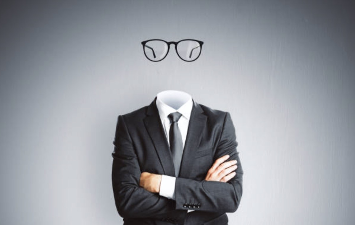 Faceless businessman in a suit with floating glasses where his head should be — a brand without identity or visibility in AI search results