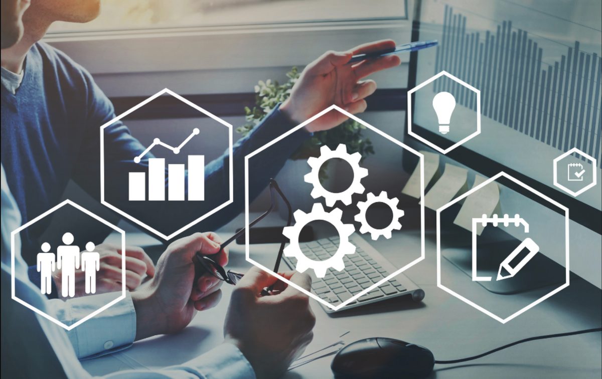 Founders reviewing year-one business operations with overlaid icons for analytics, automation, team, ideas, and planning